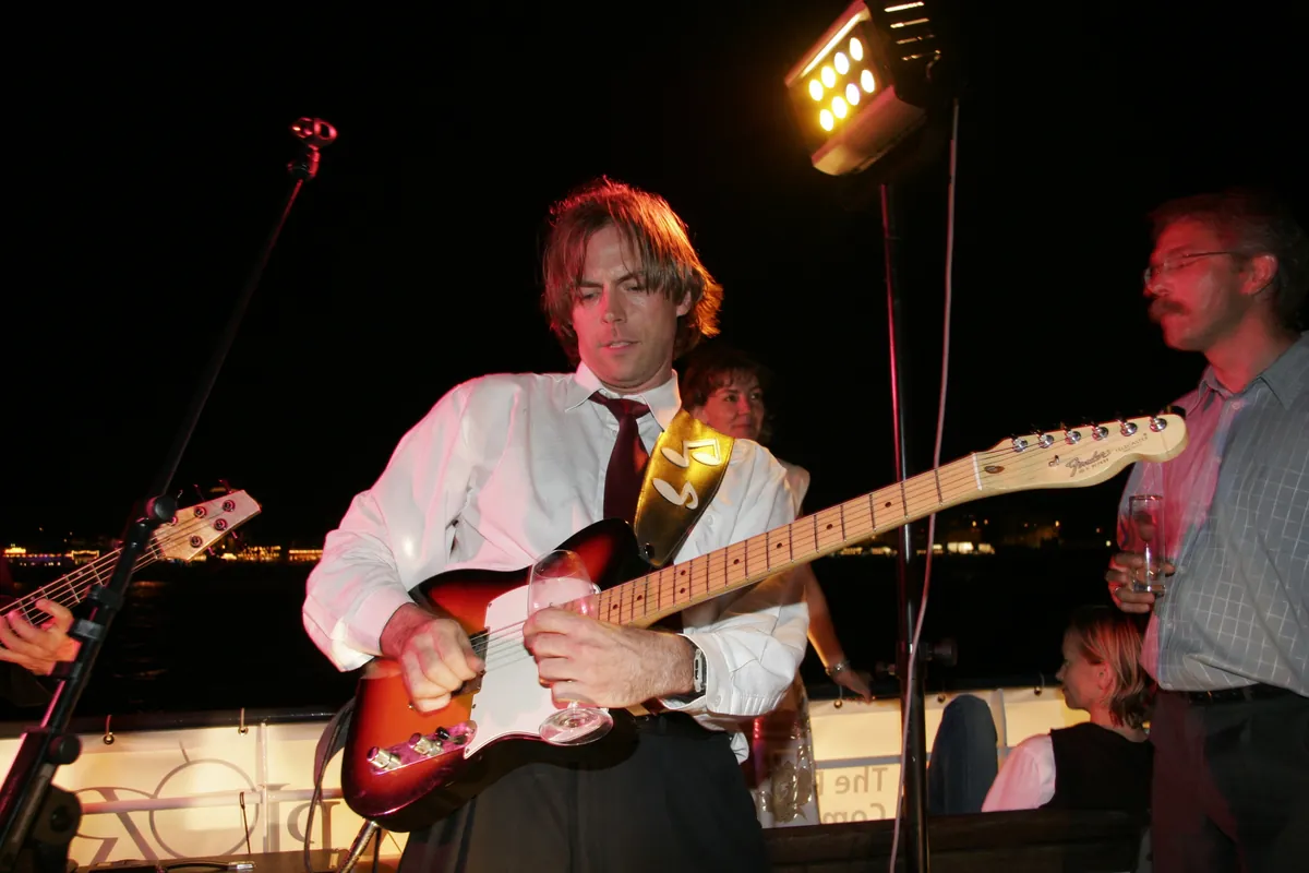 Gitarrist mit E-Gitarre bei einem Abendkonzert unter Scheinwerfern